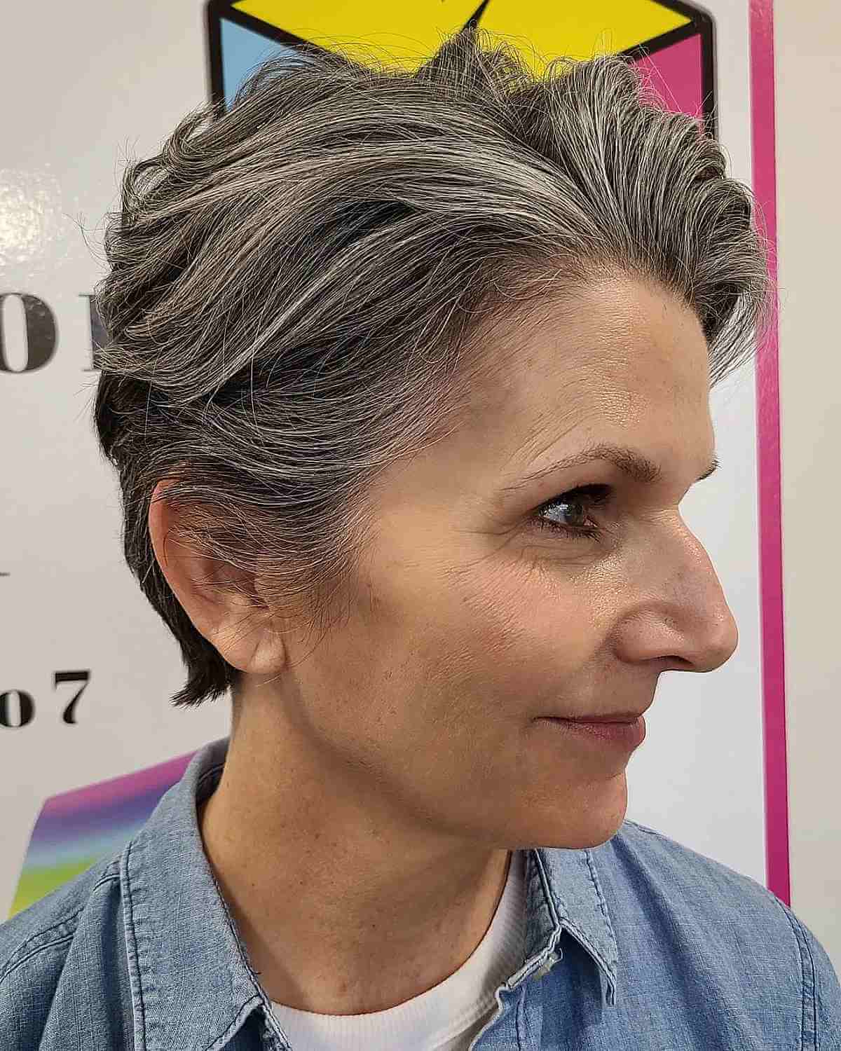 A 40-Year-Olds Wavy Bixie with Brushed Back Layers on Salt and Pepper Hair