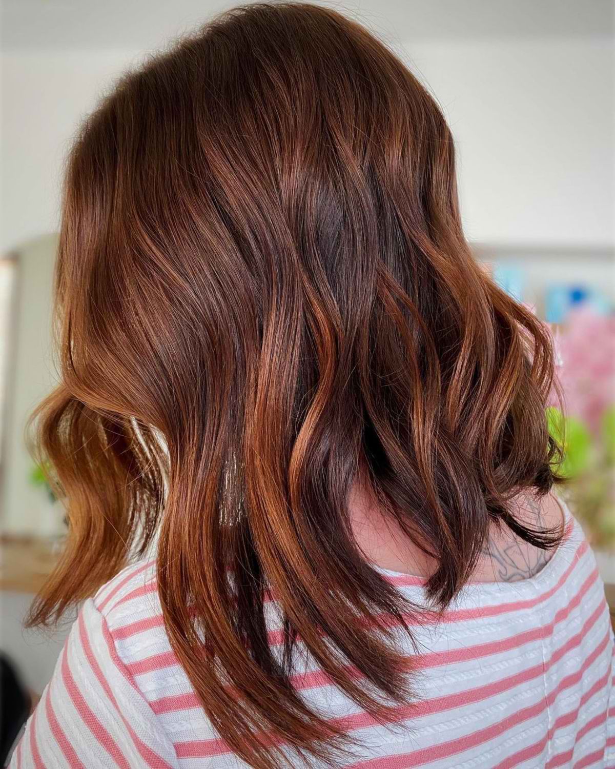 A whimsical short haircut with auburn hair color for thick hair