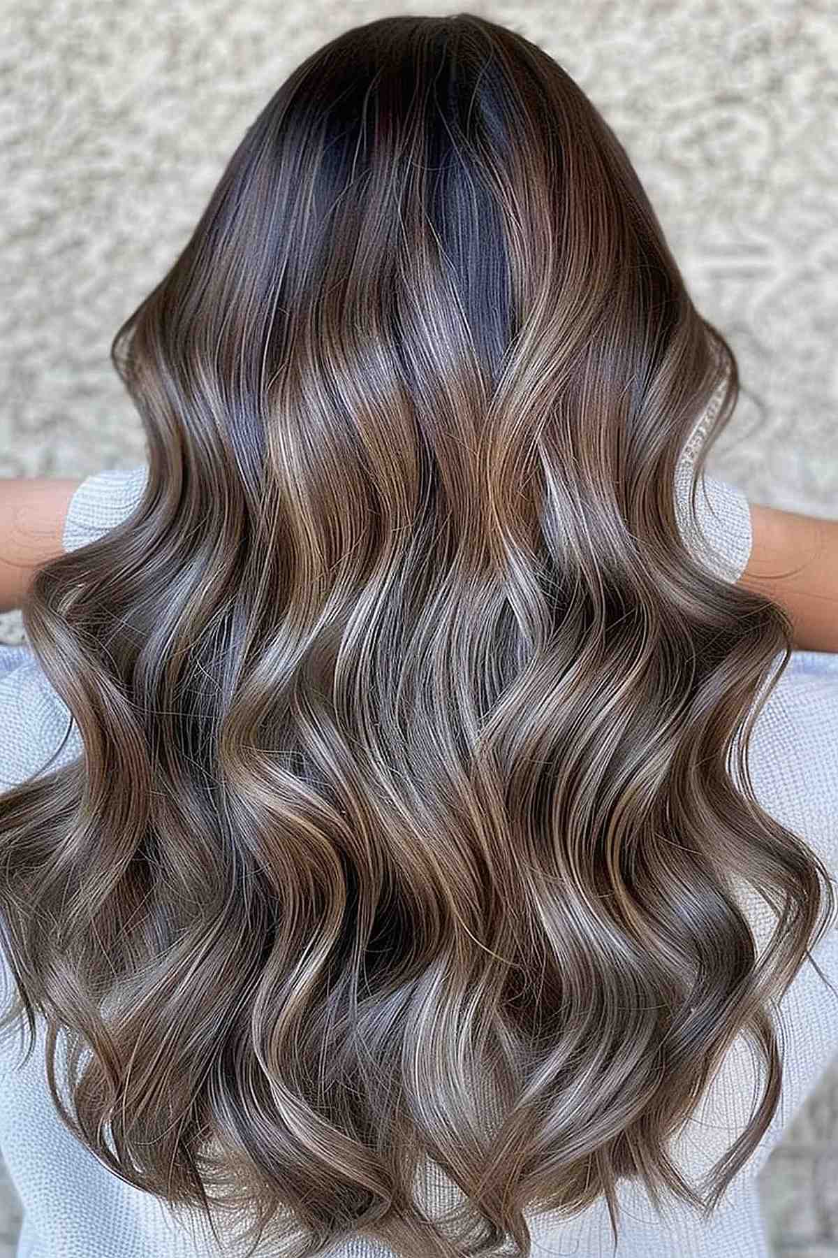 Luxurious waves in a mushroom brown balayage ombre, with colors transitioning from deep roots to lighter ends, adding dimension and volume.