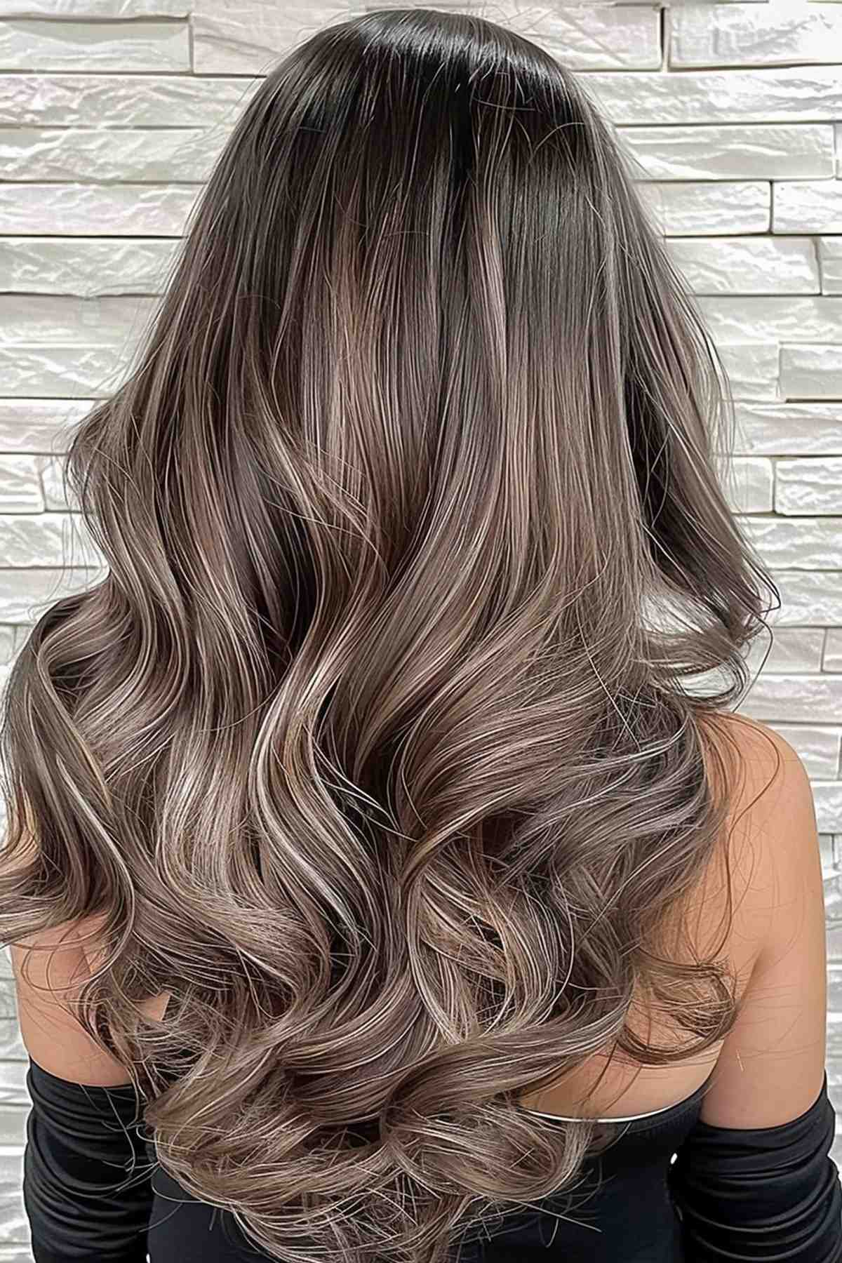 Long mushroom brown hair styled in soft waves, featuring subtle lowlights that enhance depth and texture for a rich, voluminous look.