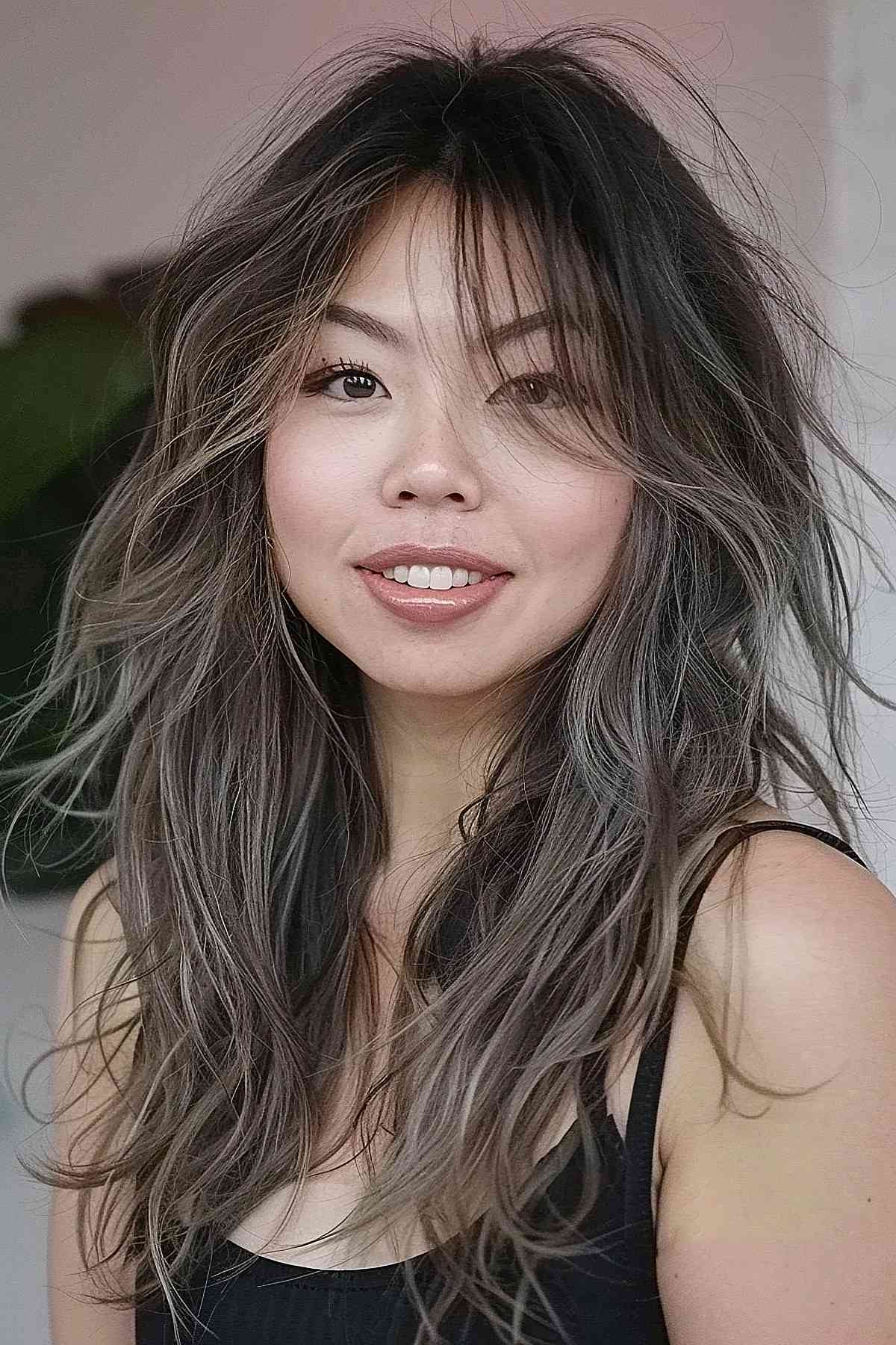 Medium-length wolf cut in mushroom brown with voluminous layers transitioning from dark roots to lighter tips, enhancing texture and movement.