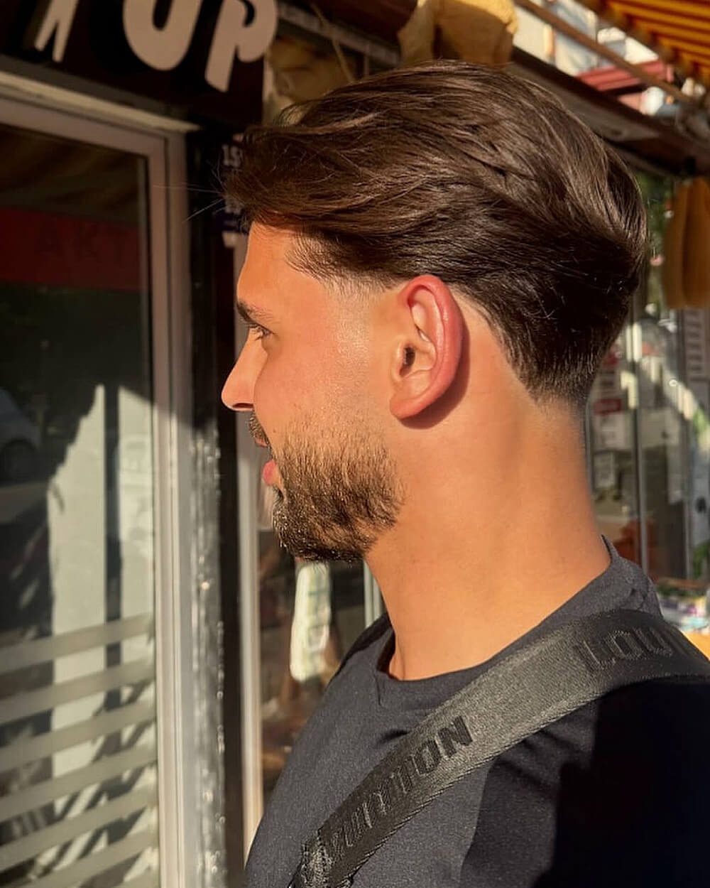 Natural swept-back hairstyle with tapered edges and low taper fade for thick hair