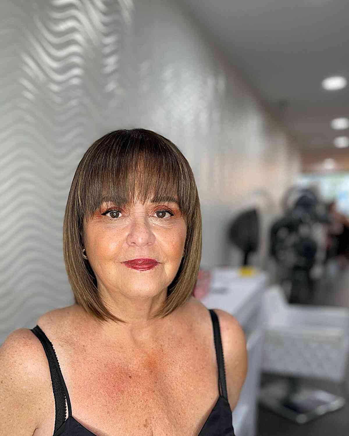 Neck-Grazing Brunette Bob with Bangs for Ladies Aged Sixty with Fine Hair
