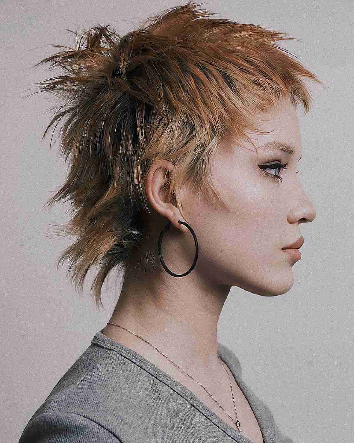 Spiky textured mullet with choppy layers and warm highlights on fine to medium hair