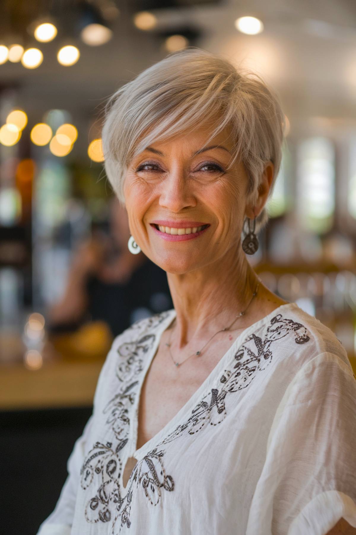 Short pixie bob for women over 60 with soft layers and a sweeping fringe for an elegant, youthful feel