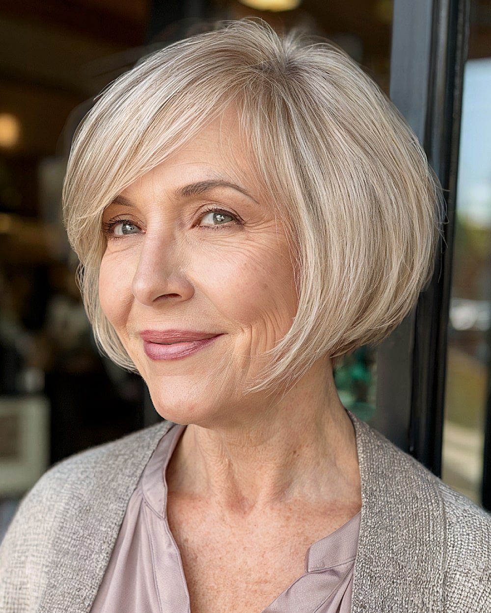 Soft pixie bob with side part and beige blonde color for mature women