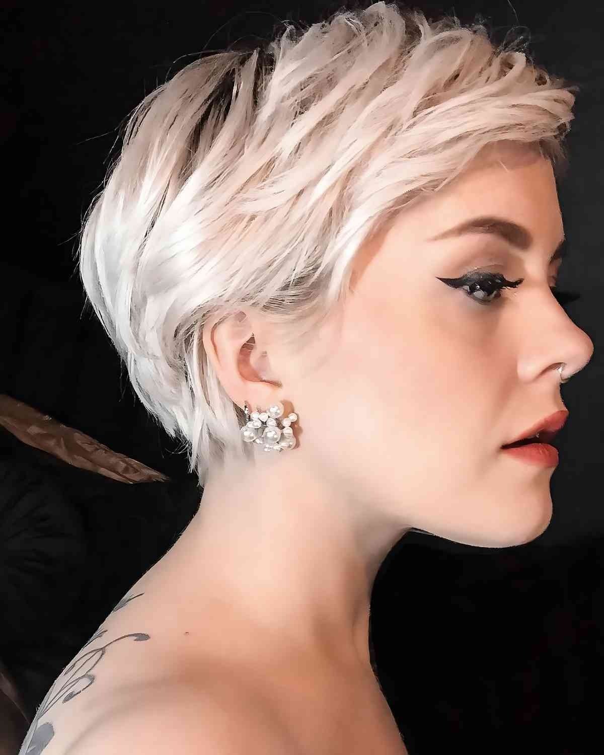 Side view of a platinum blonde pixie cut with textured layers inclusive hairstyle