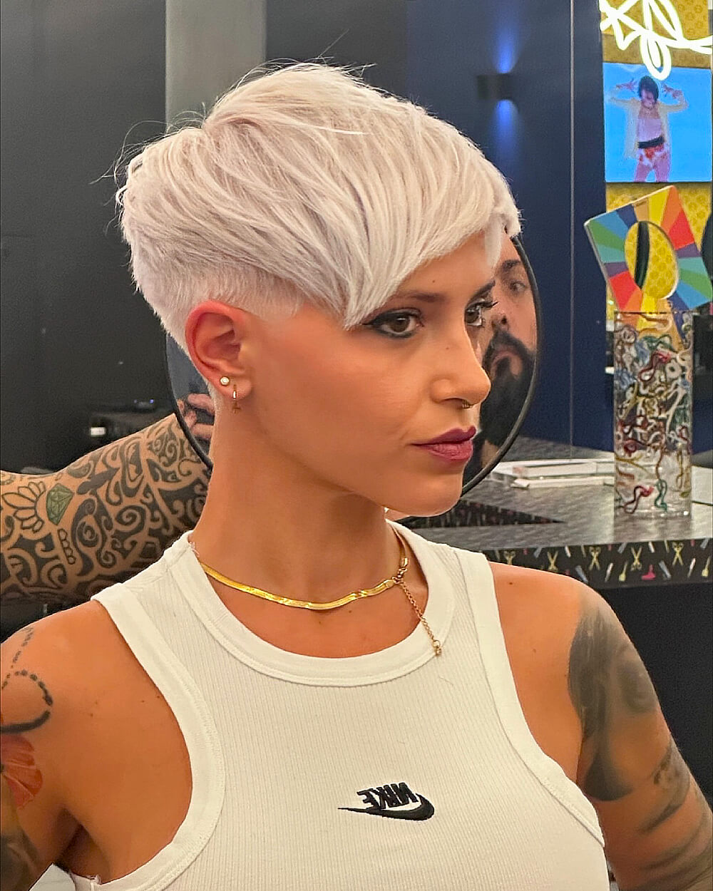 Platinum textured pixie cut with long side fringe and faded undercut on thick straight hair