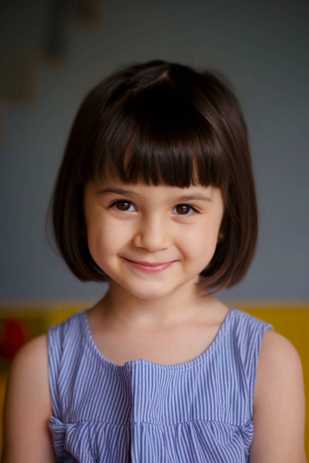 Above-the-shoulders bob haircut with blunt bangs for preschool girls