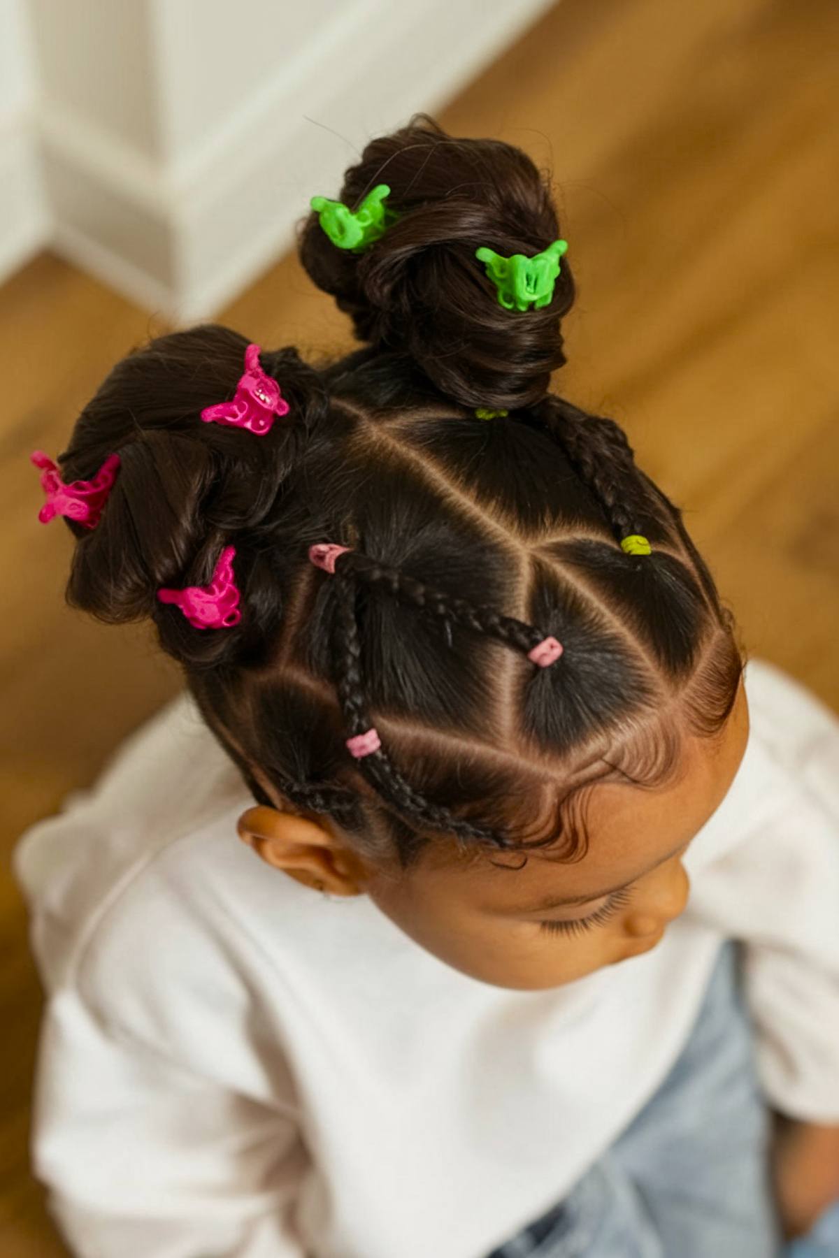 Double bun toddler hairstyle with colorful clips