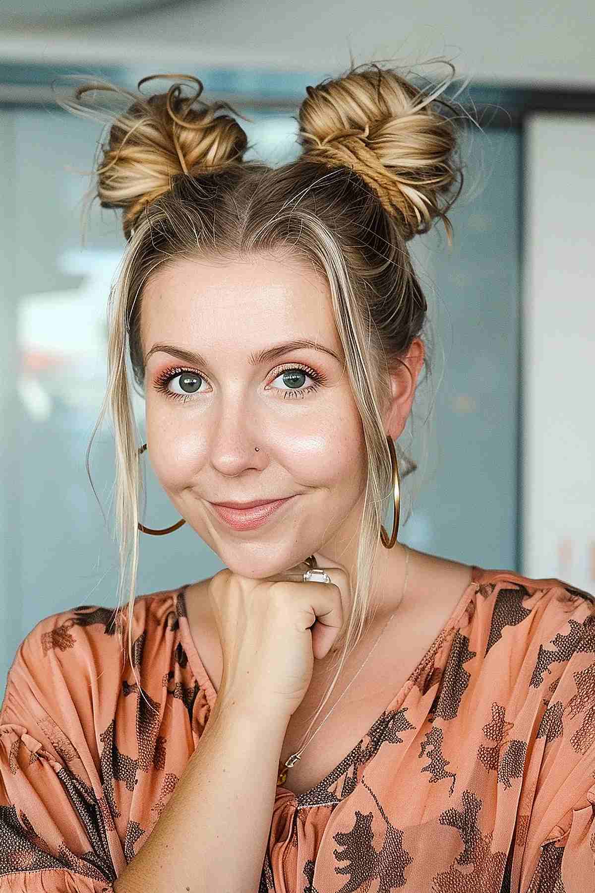 Woman with playful space buns hairstyle and loose tendrils, perfect for travel