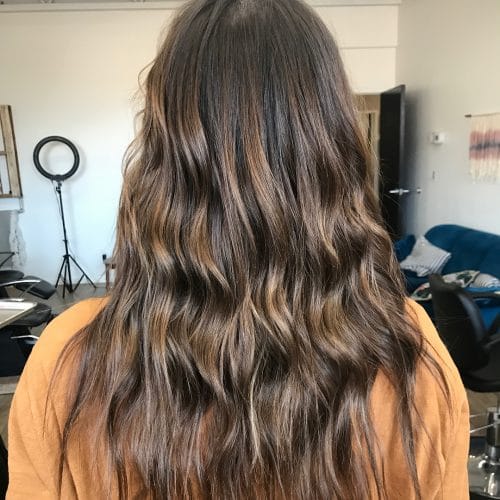 Tousled chocolate brown hair with blonde highlights