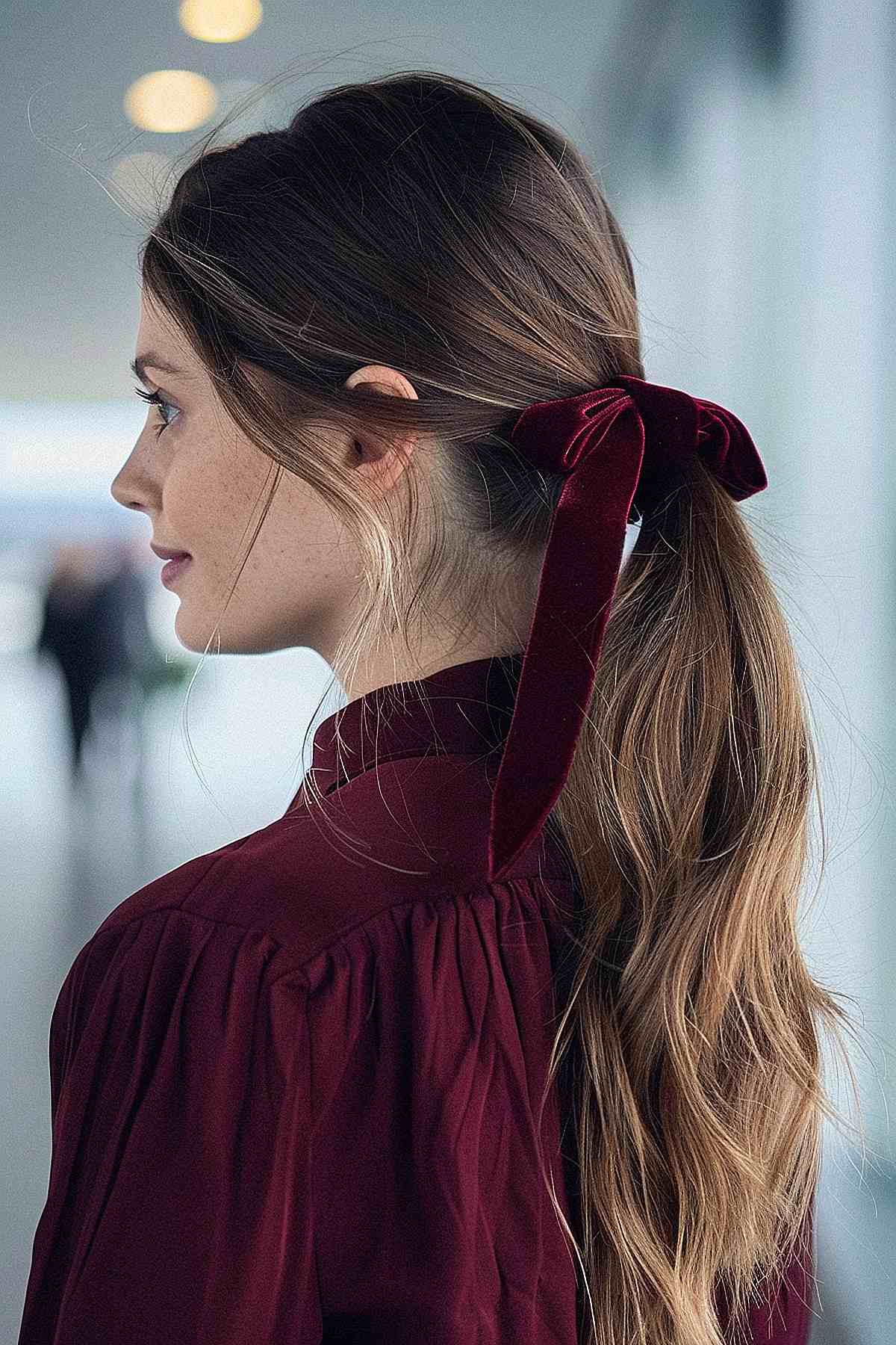 Woman with preppy velvet ribbon ponytail hairstyle at the airport