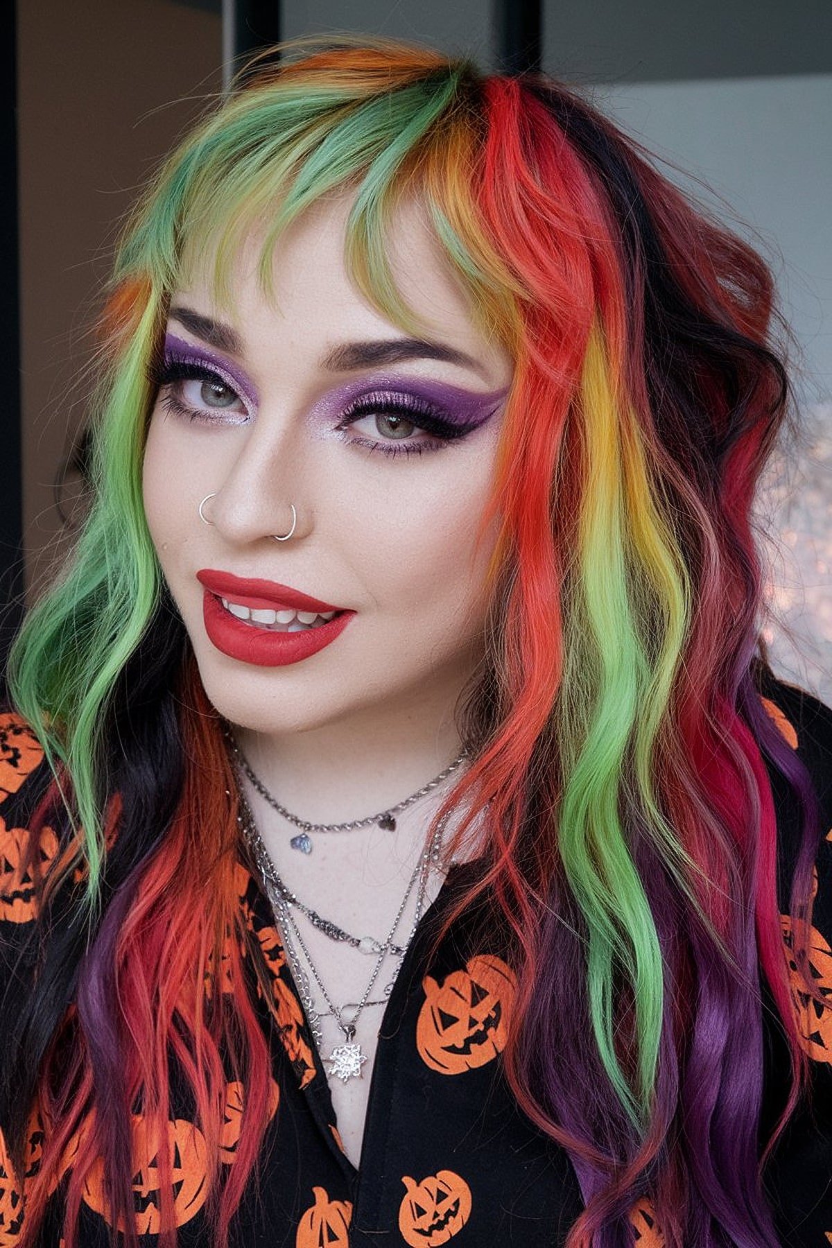 Halloween-inspired rainbow hair with neon green, orange, red, and purple dye