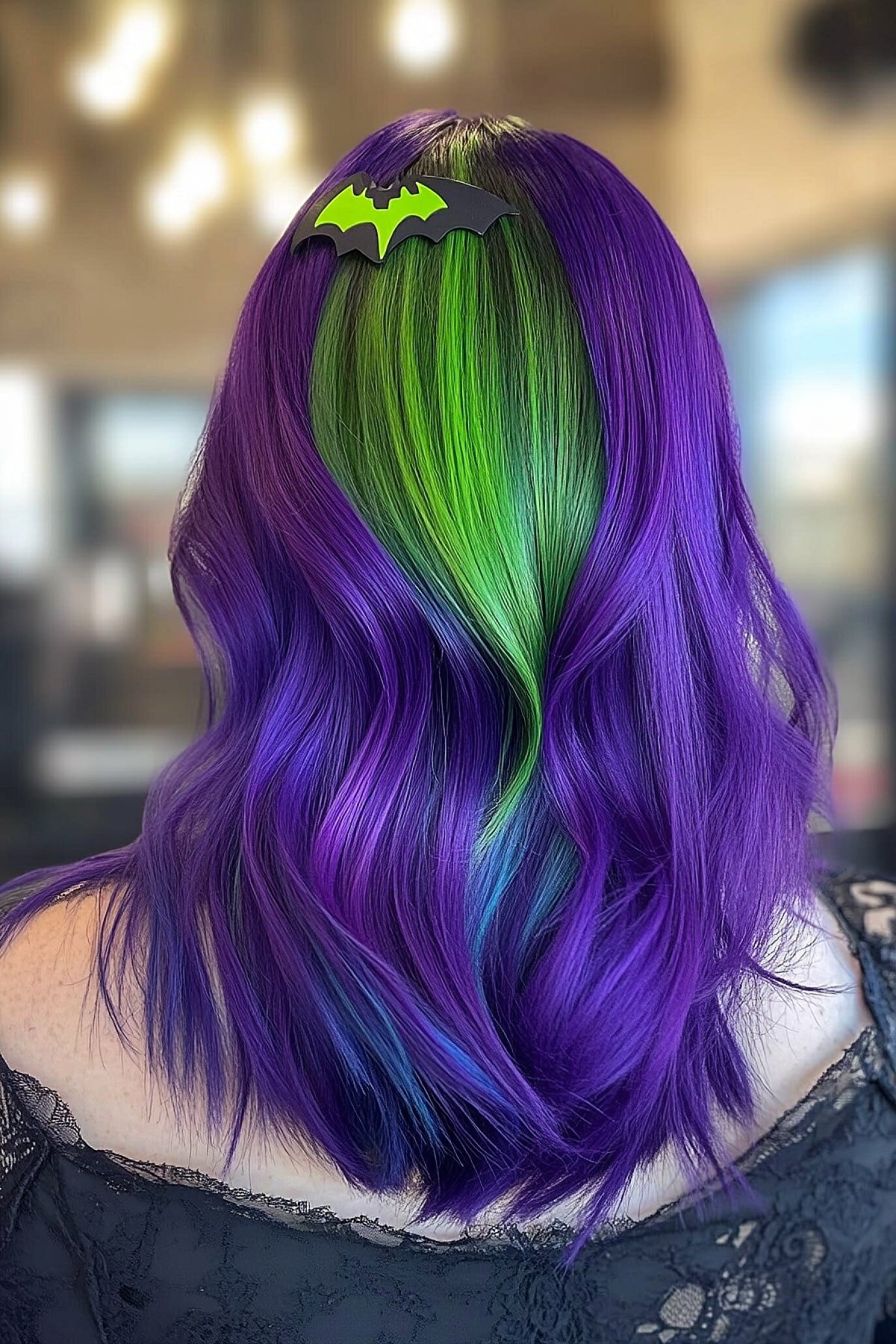 Wavy purple and green hair with a bat clip for a spooky Halloween look