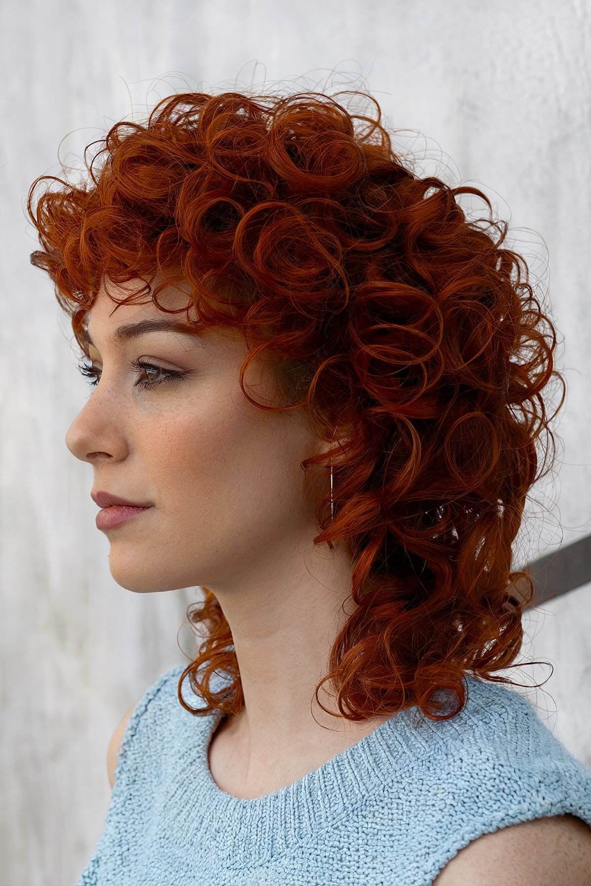 Red curly mullet hairstyle with bold layers