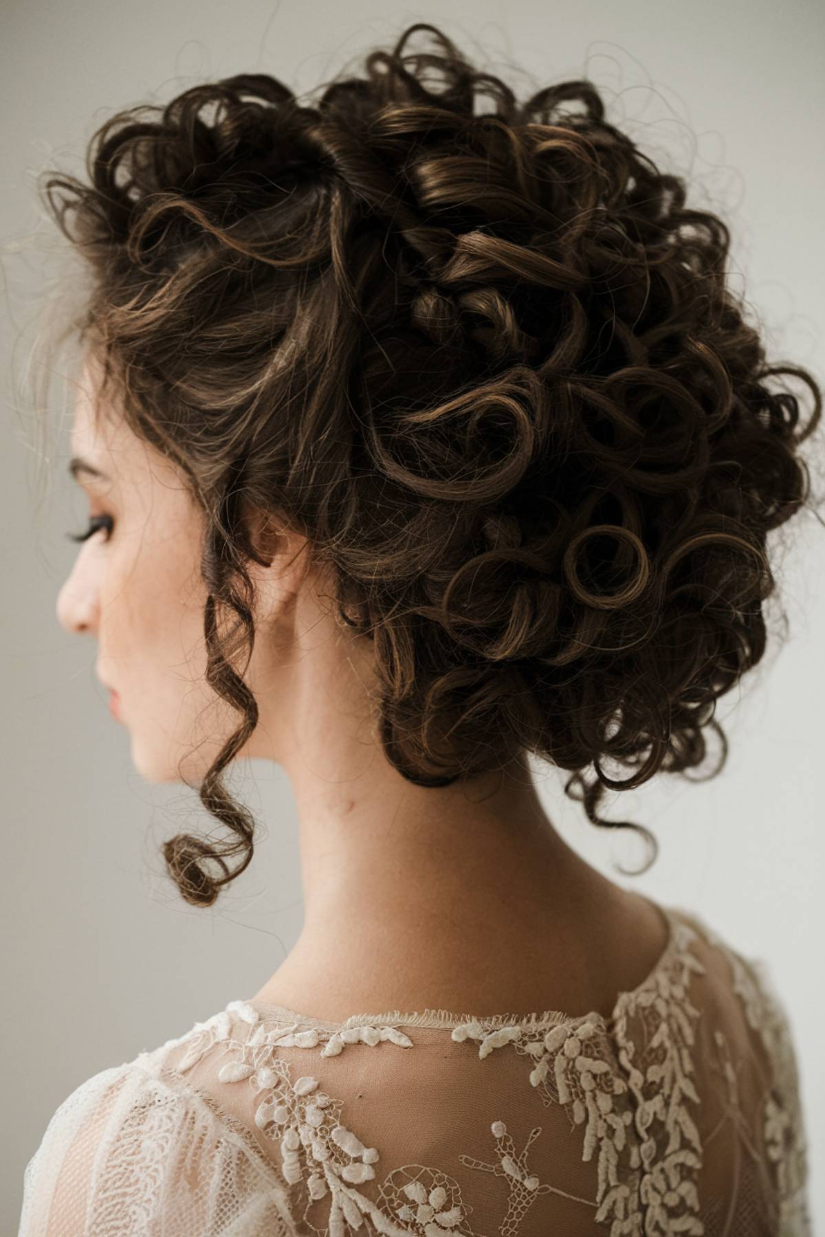 Curly Ringleto bun with tight spiral curls and soft tendrils for a vintage-inspired look