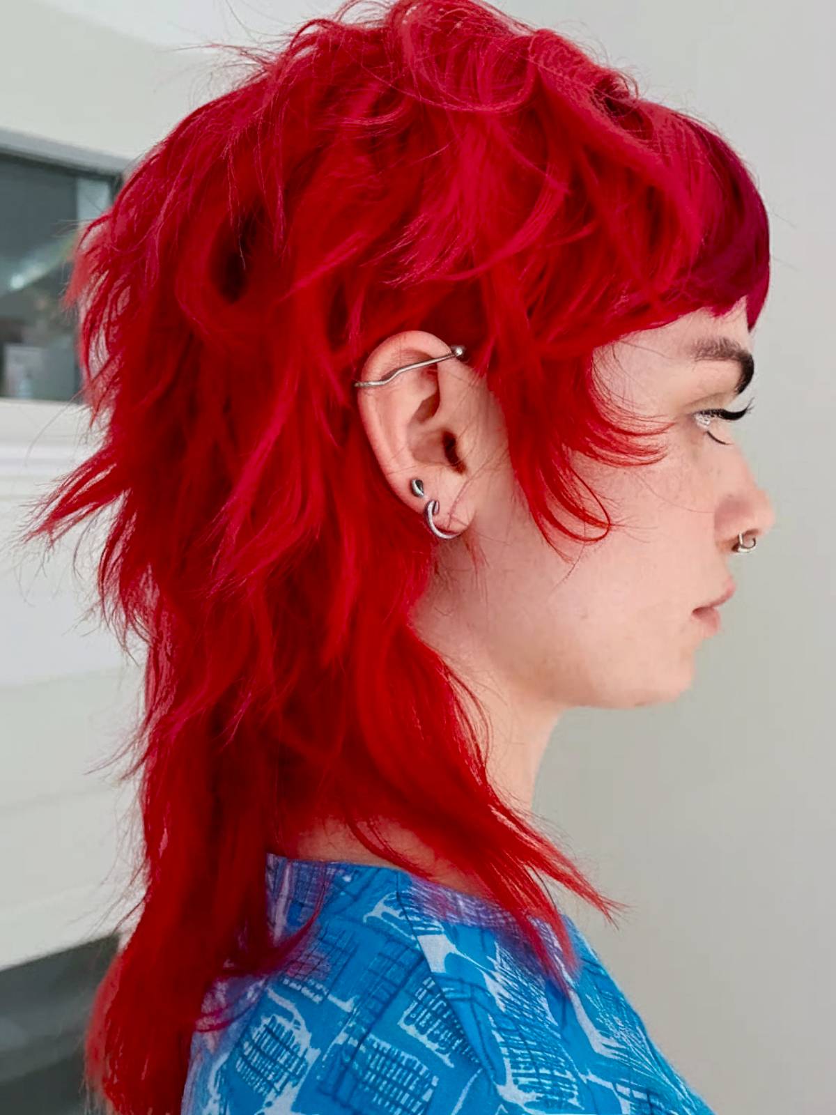 Rocker shag mullet with razored ends and vibrant red color for a bold, edgy look