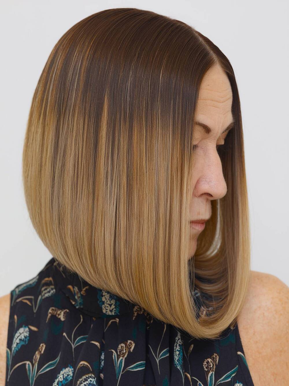 Classic round bob with soft layers, giving a smooth and polished look for older women