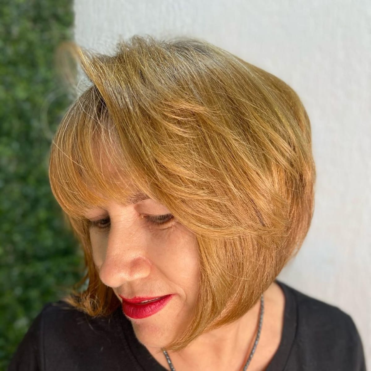Tapered rounded bob with feathered layers for women over 60