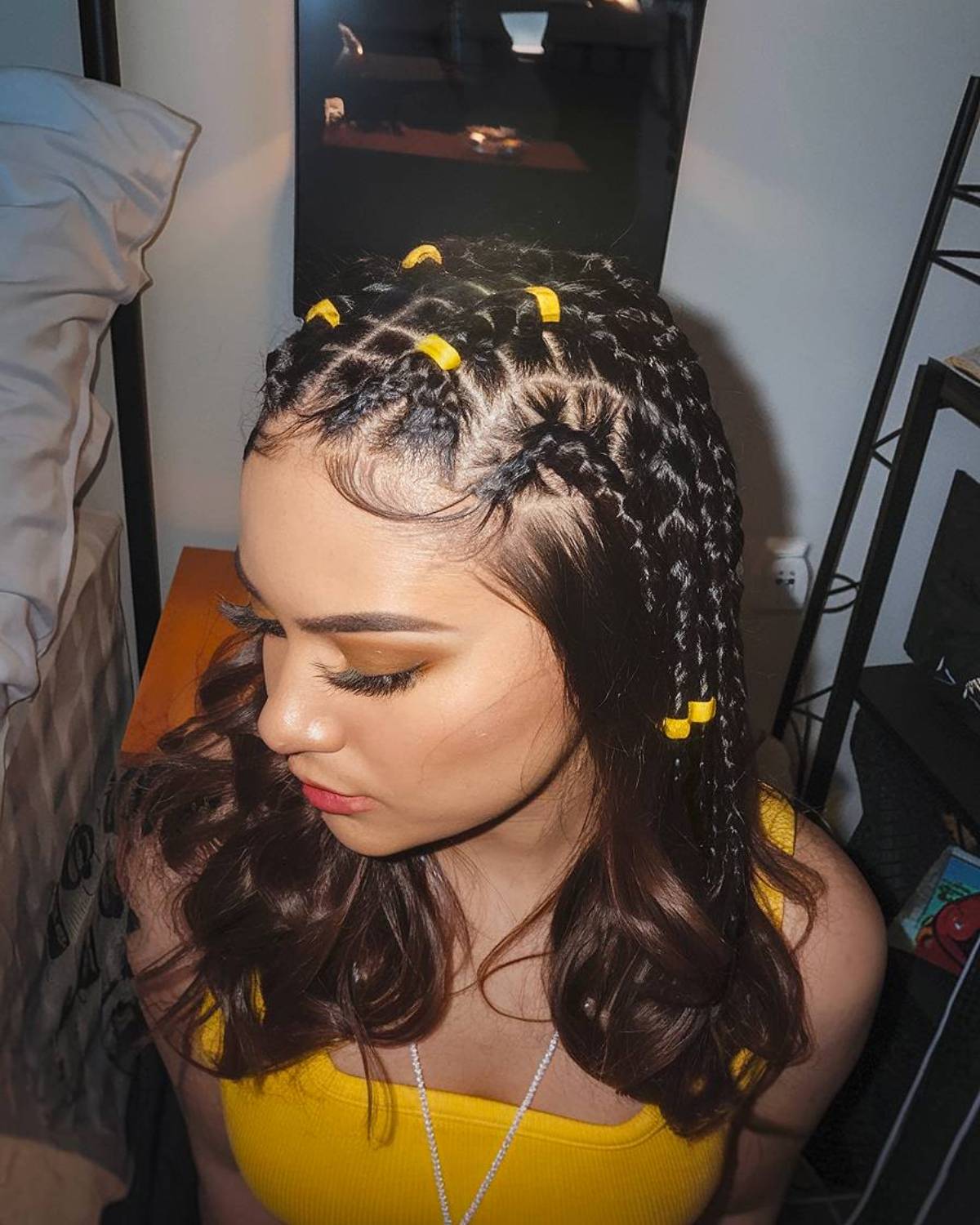 Creative Latina hairstyle with sectioned rubber band braids and loose waves for a trendy and playful finish