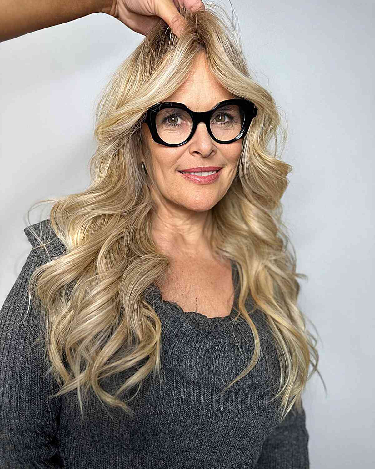 Sandy Blonde Balayage with Long Voluminous Waves for Older Women Over Sixty with Glasses