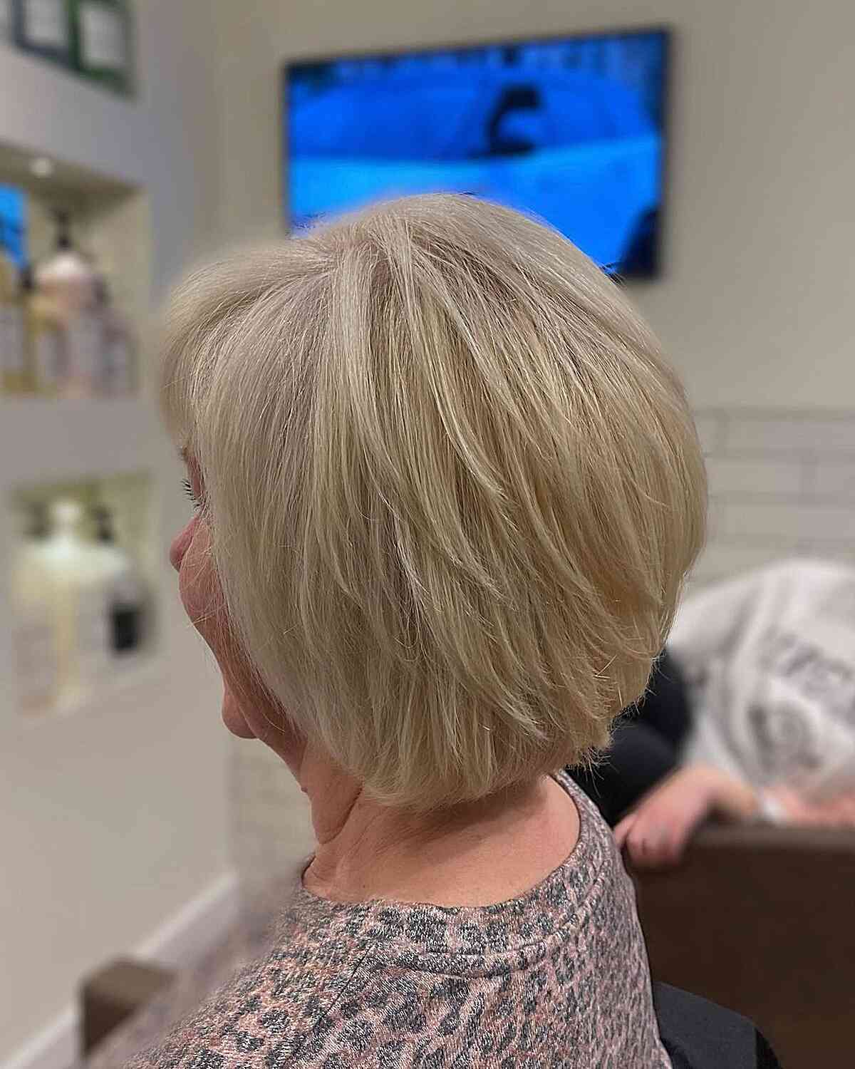 Neck-Grazing Sandy Blonde Feathered Inverted Bob with Wispy Layers for Seniors Over 60