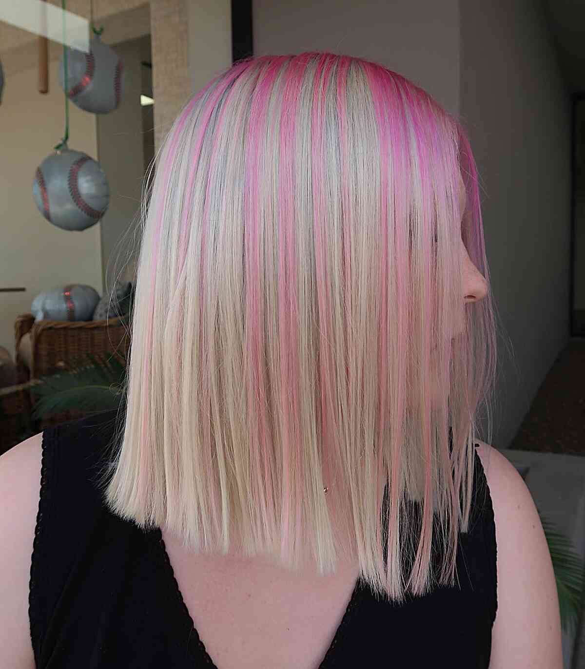 Sassy Pink Streaks Hair Color Idea for ladies with a long bob cut