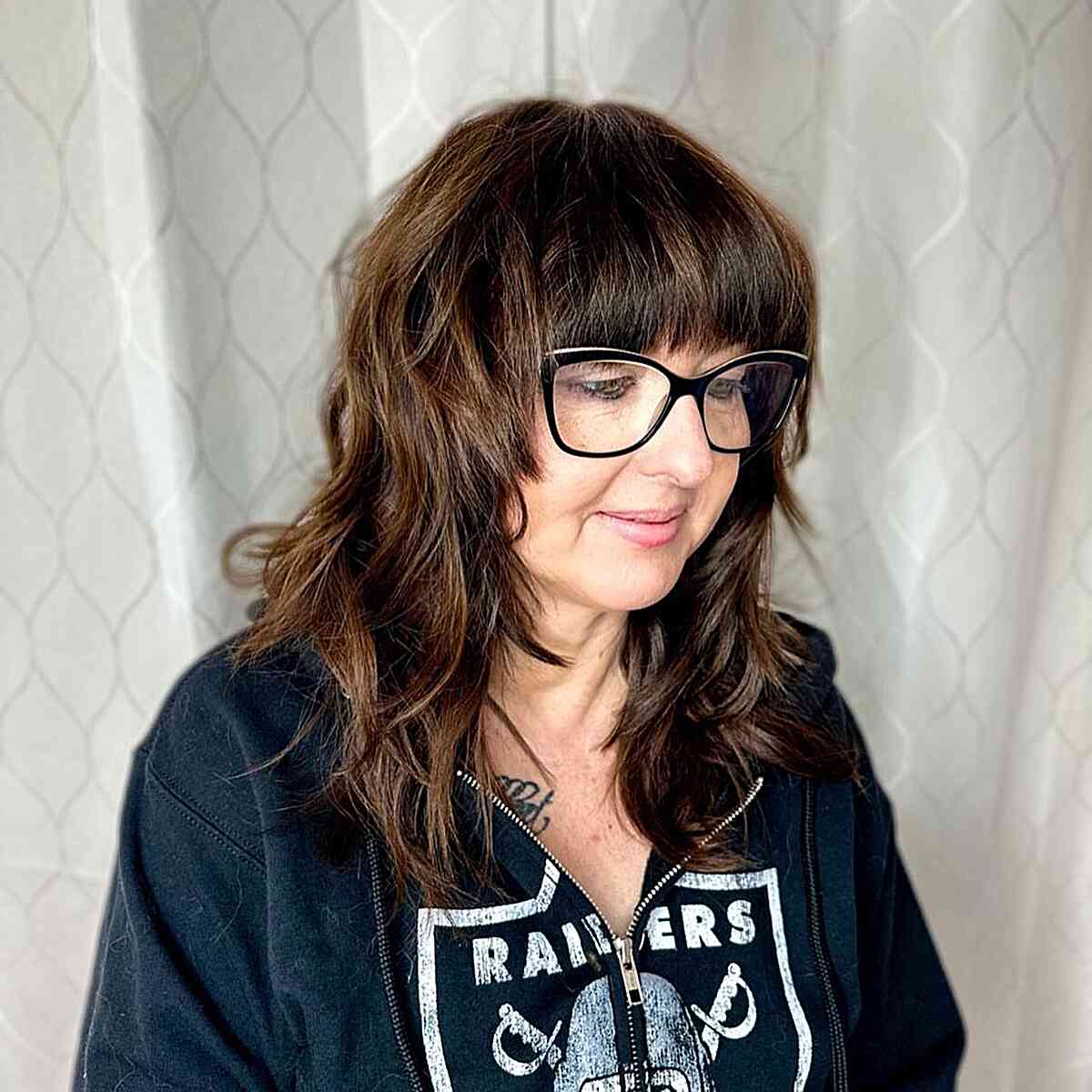 Mid-Length Shaggy Feathered Layers with Blunt Bangs for Older Women Over 60 Wearing Glasses