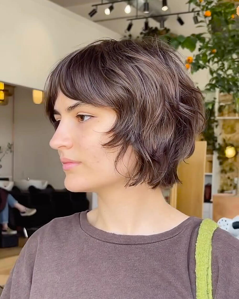 Shaggy pixie bob with tousled ends on short wavy hair for a textured, low-maintenance style