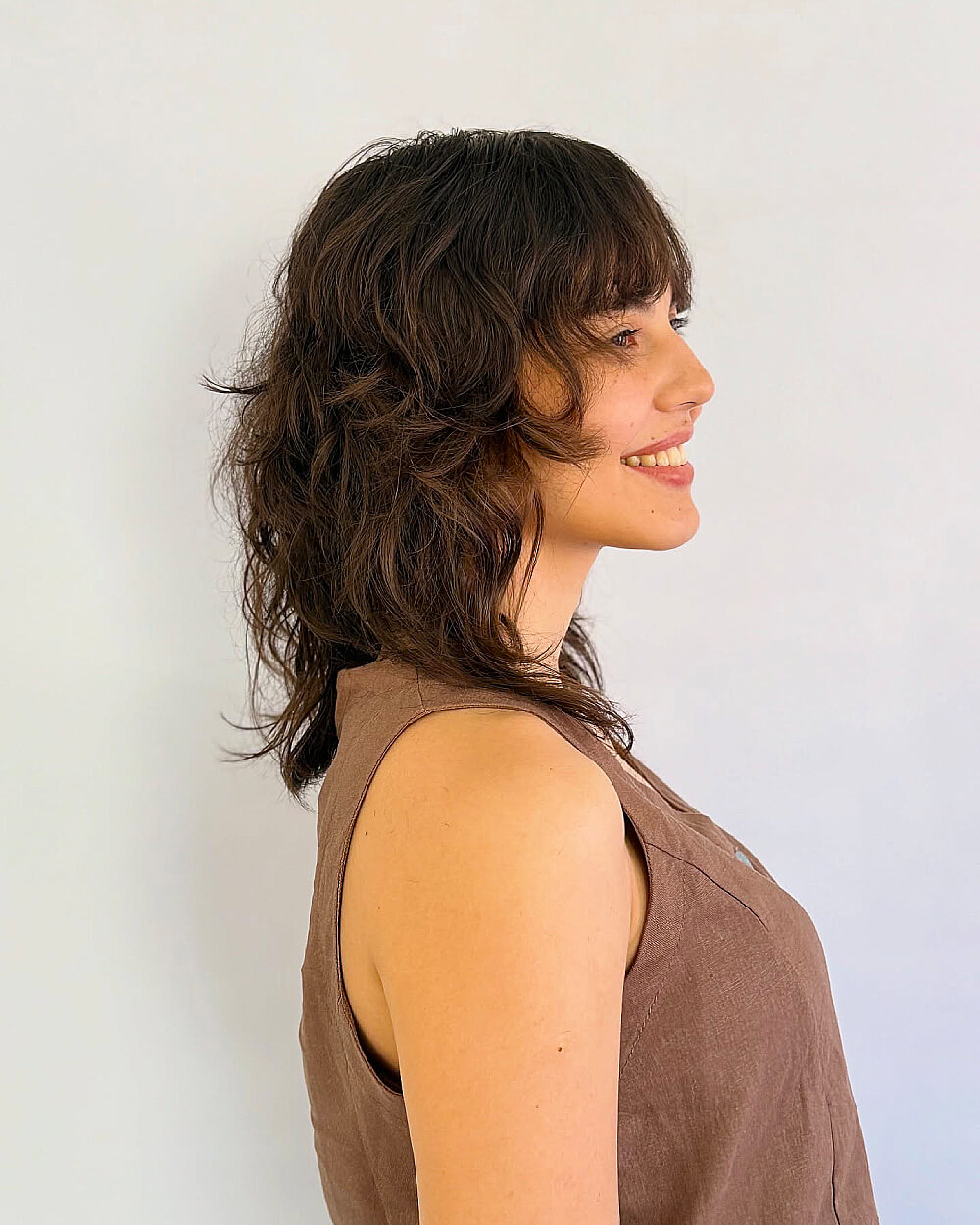 Shaggy wavy wolf cut with fringe on medium layered hair for thick, naturally wavy texture