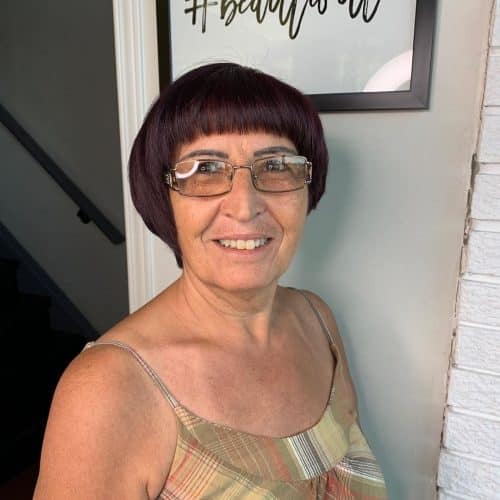 Short asymmetrical bob on woman in her 50s wearing glasses