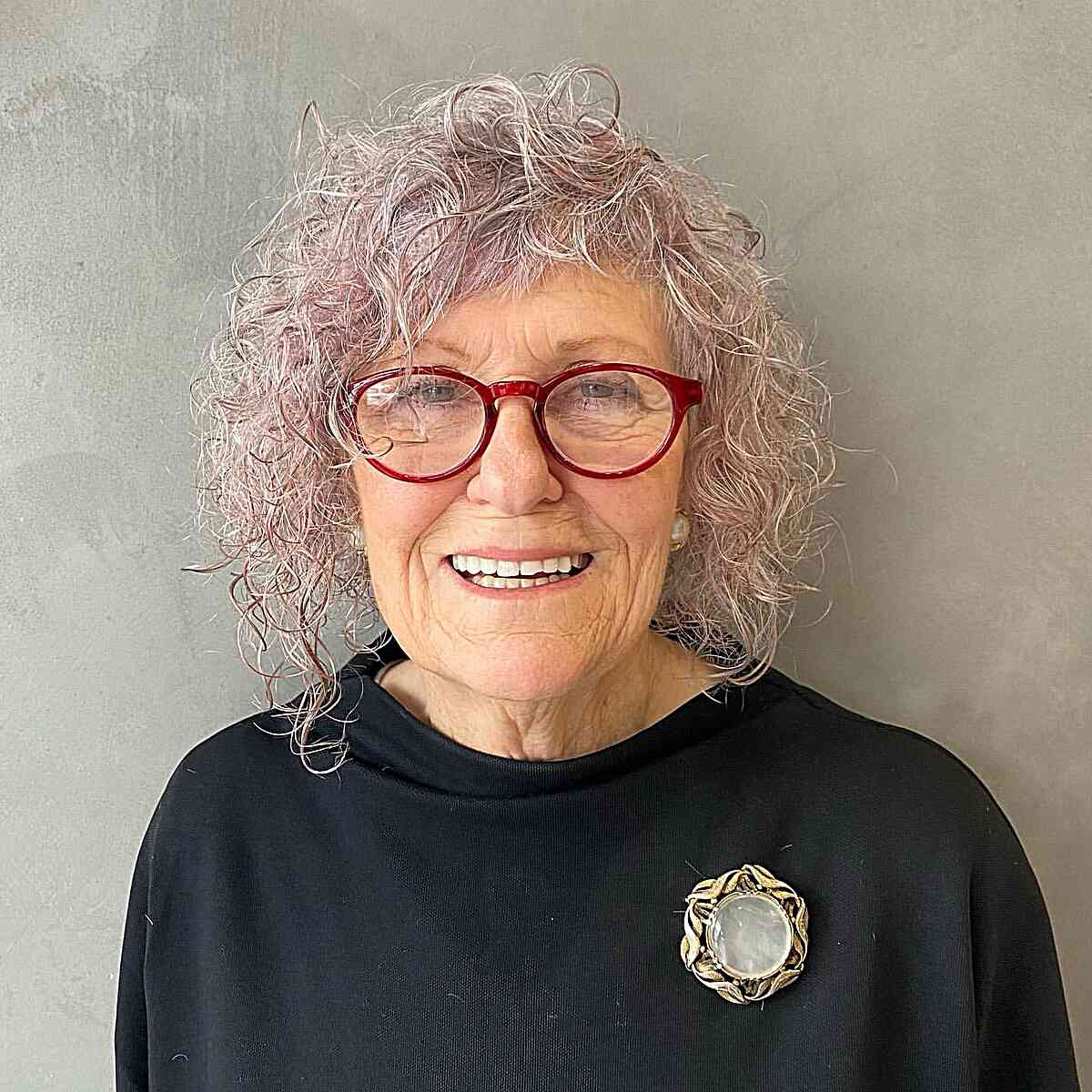 Short Asymmetrical Platinum Curls for Older Women Over 60 with Glasses