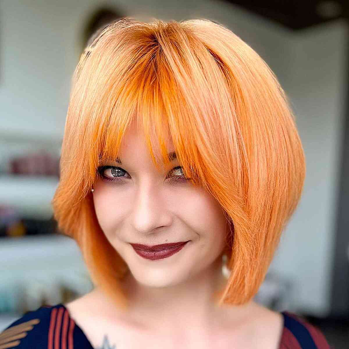 Short Bright Orange Layered Bob with Fringe for women with an edgy style