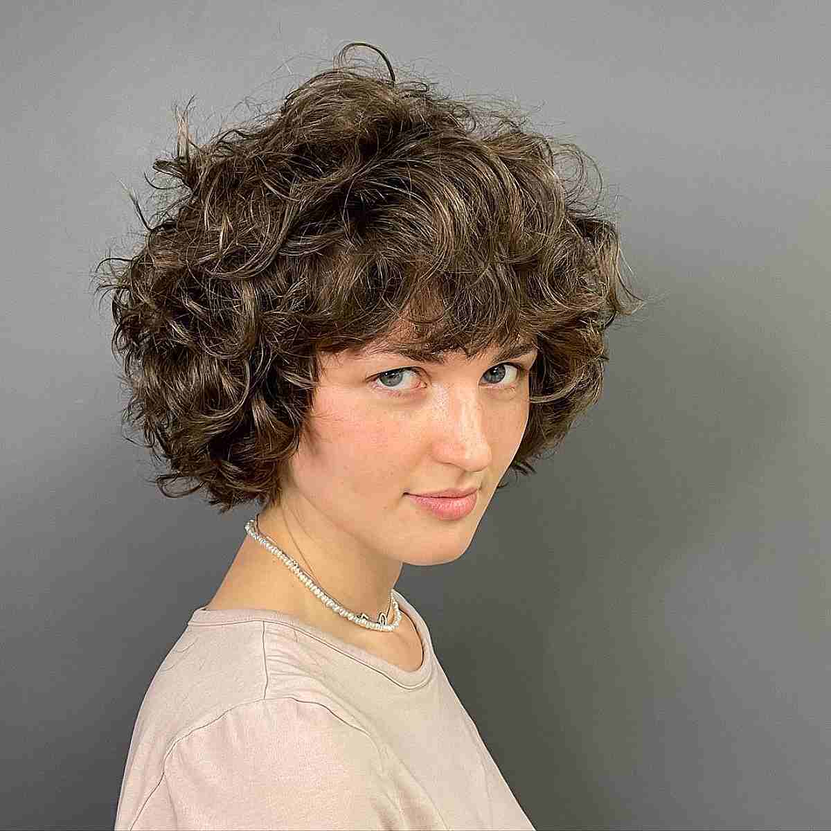 Short Brown Curly Bob with Razor Cut Layers and Bangs