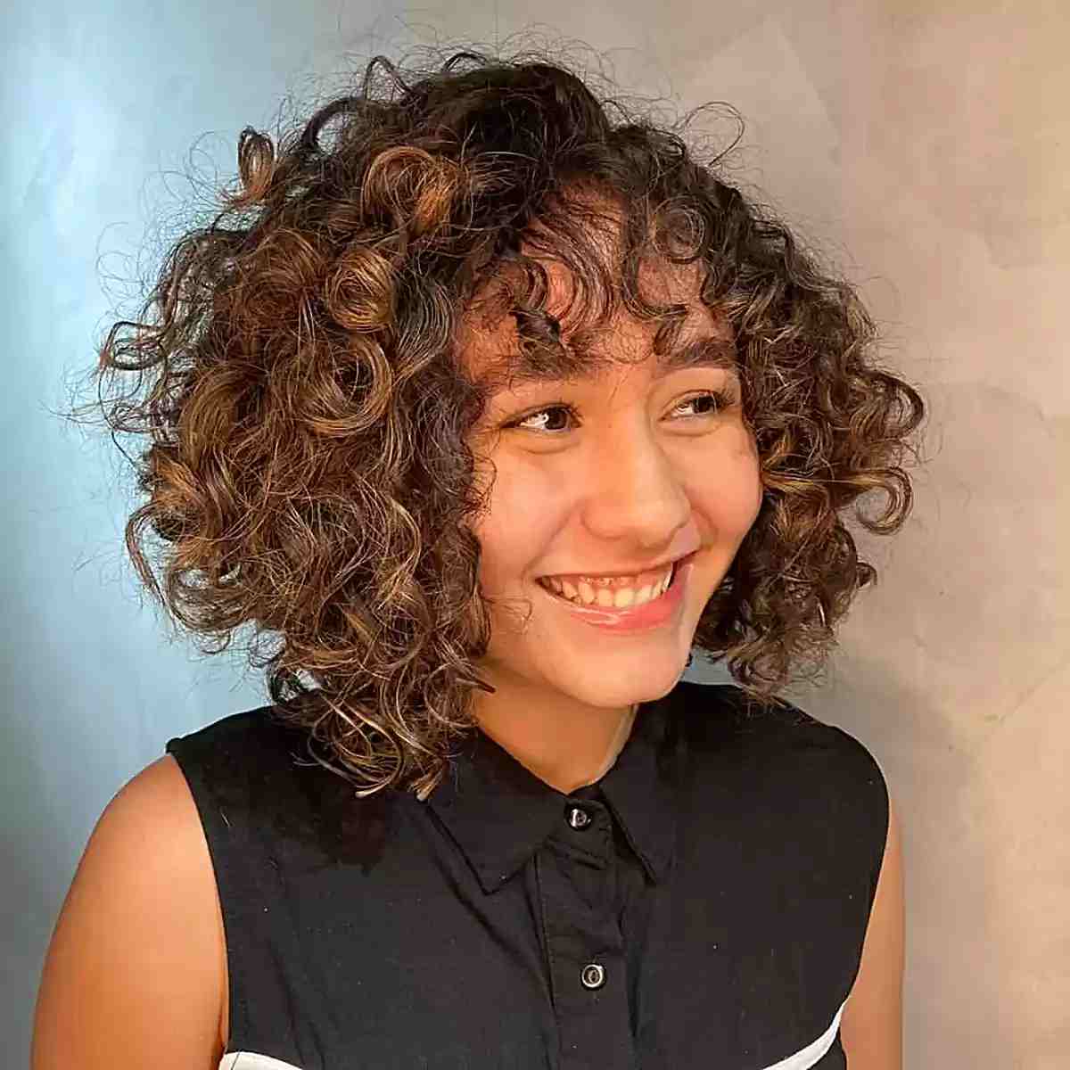 Short Curly Hair and Curly Bangs with Graduated Layers for Highlighted Brown Locks