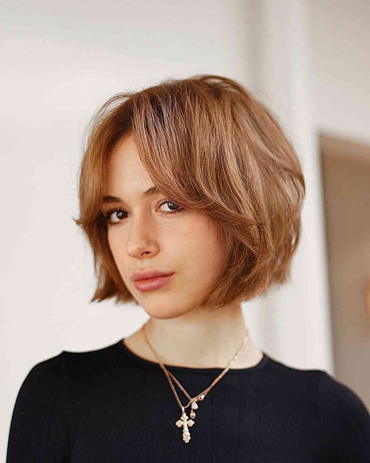 Short Golden Brown Layers on a Bob Cut with Bangs