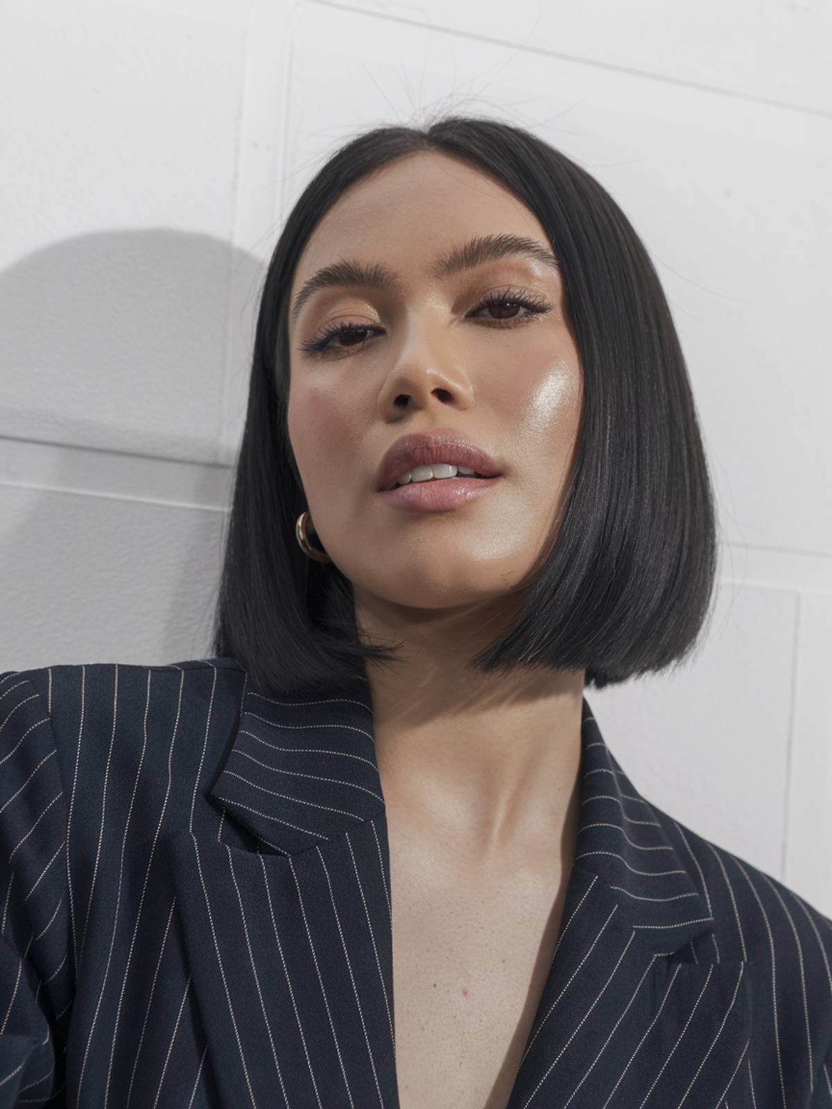 A sleek, jet-black short bob with a middle part, offering a bold and powerful Latina hairstyle.