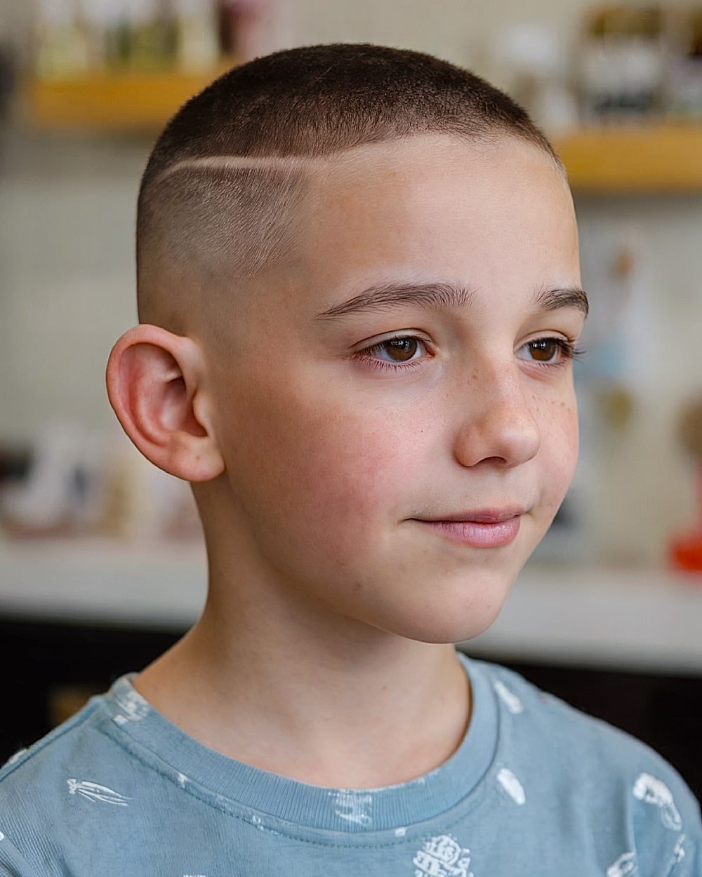 Boys buzz cut with hard part design and skin fade sides