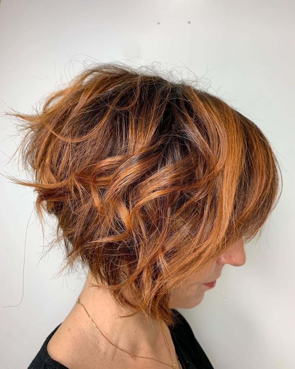 short layered dark copper brown hair with caramel highlights