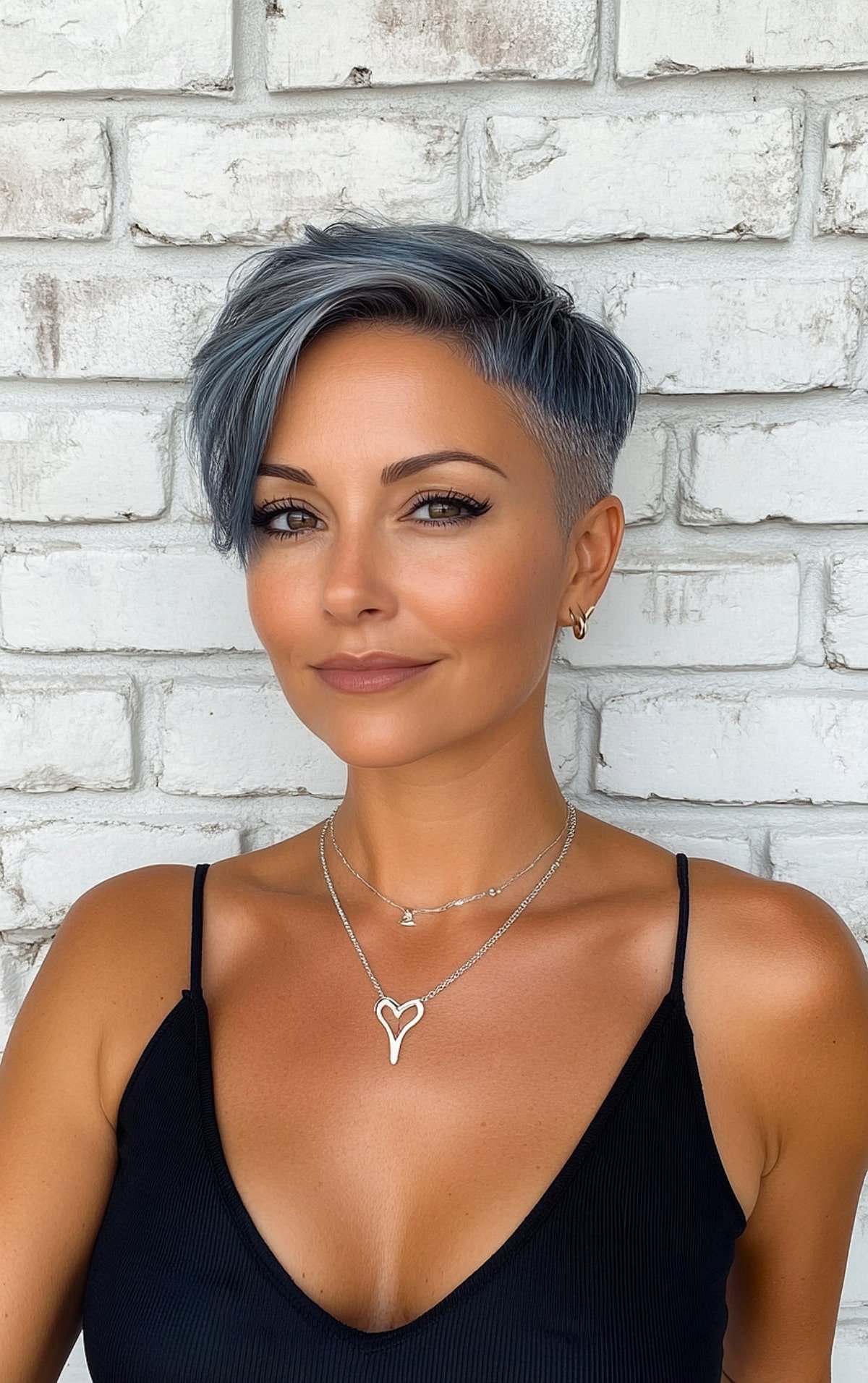 Edgy pixie cut with side fringe and shaved sides in ash-blue color