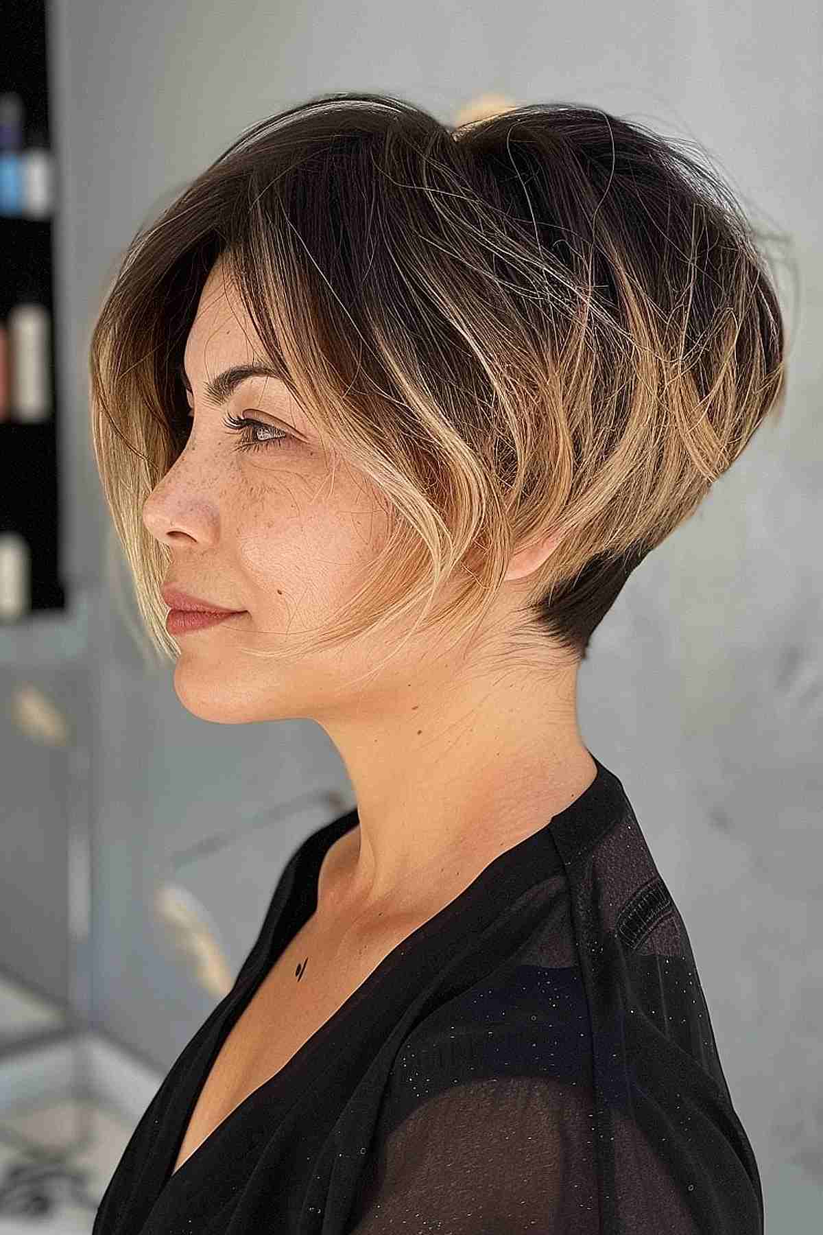 Short stacked pixie bob with dark roots and light blonde highlights