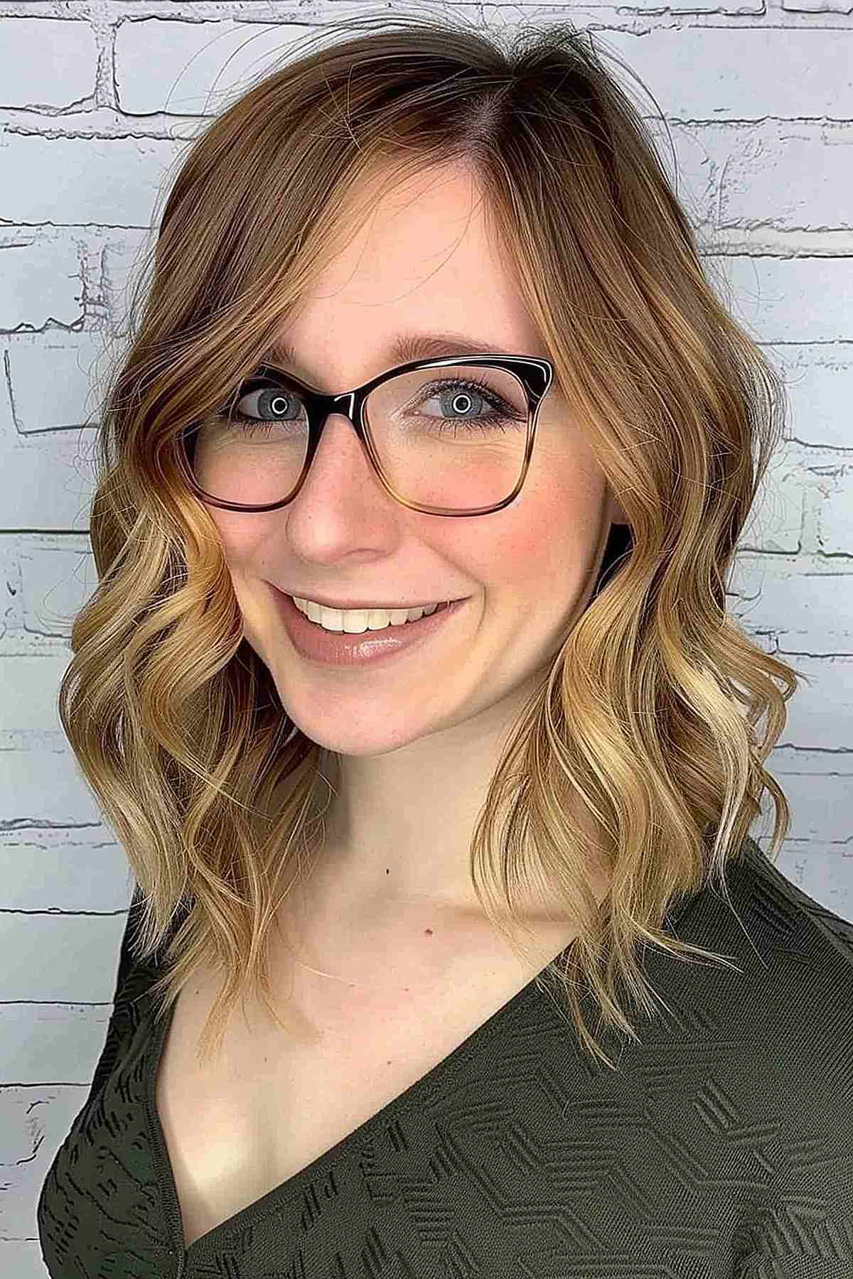 Woman with glasses wearing a shoulder-length bob with choppy layers and balayage highlights