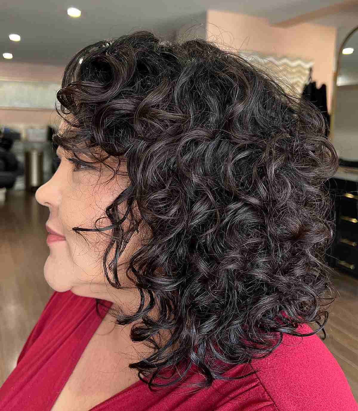 Shoulder-Length Curly Haircut with Curly Bangs for an Old Lady