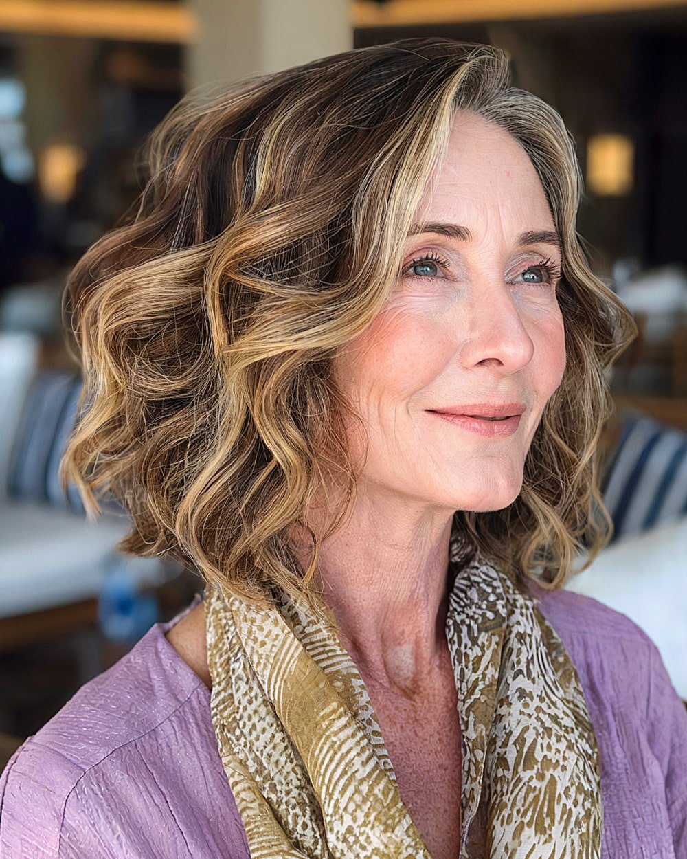 Shoulder-length wavy hairstyle with side part and honey blonde highlights for older women