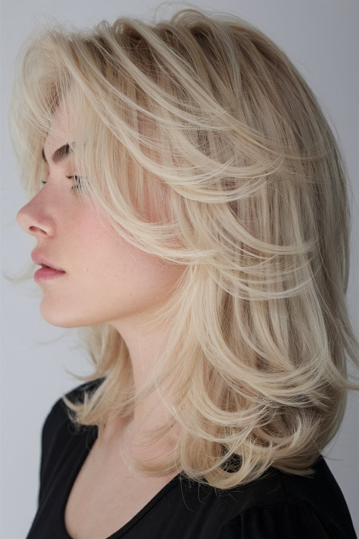 Shoulder-length layered haircut with feathered ends