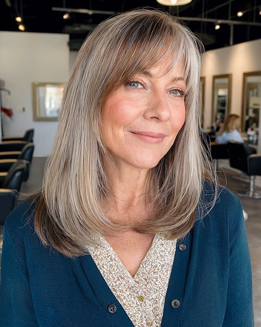 Medium hairstyle with side-swept bangs for women over 60 with a large forehead
