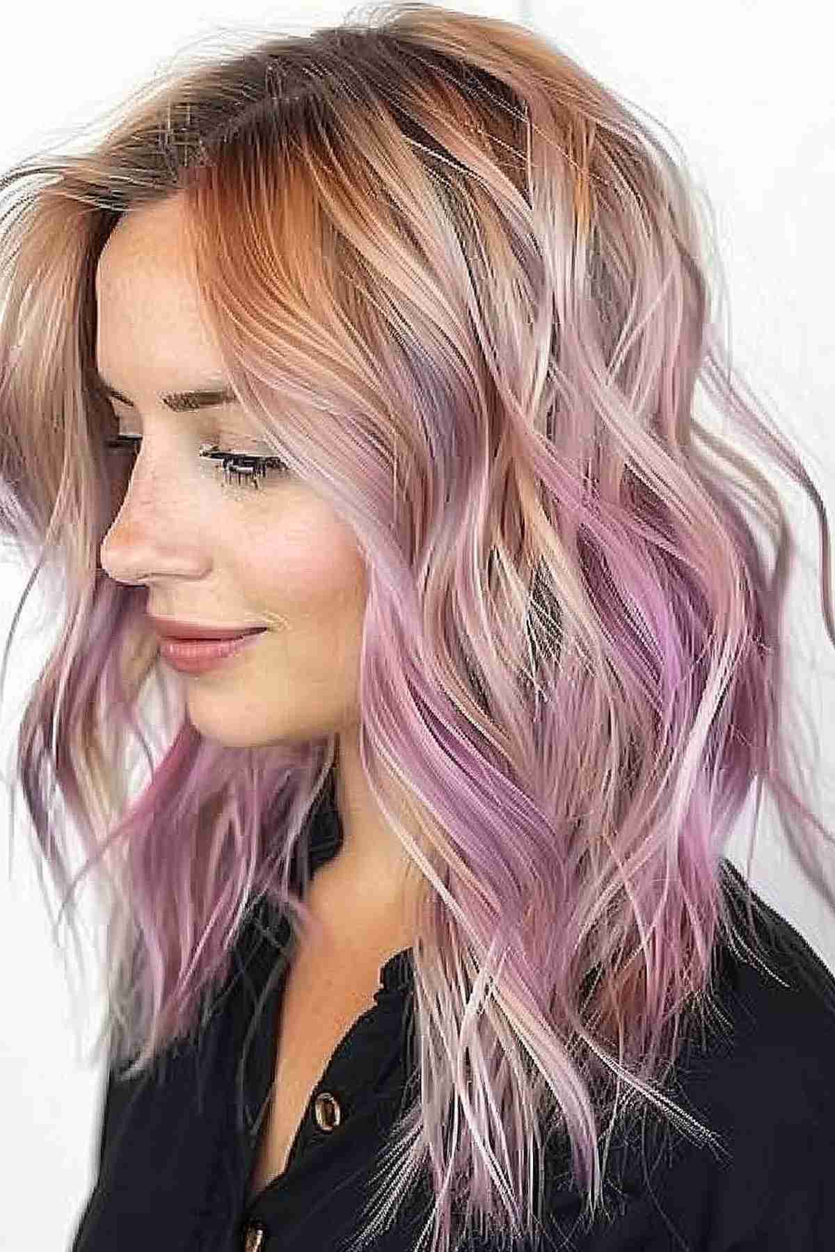 Medium-length wavy hair transitioning from rose pink roots to silver ends, demonstrating a modern balayage technique suitable for youthful and playful styles
