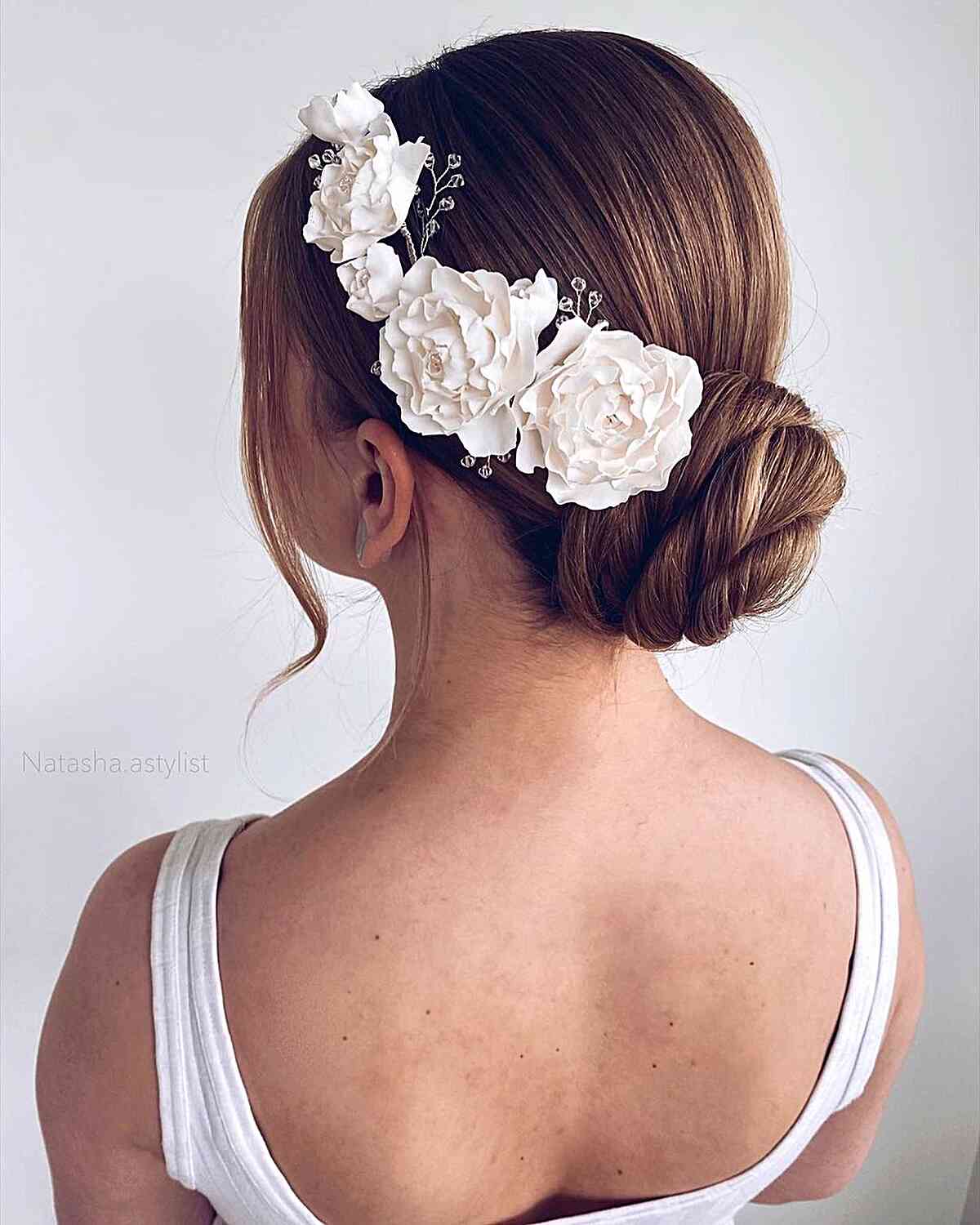 Simple and Modern Updo with Flowers for a Wedding