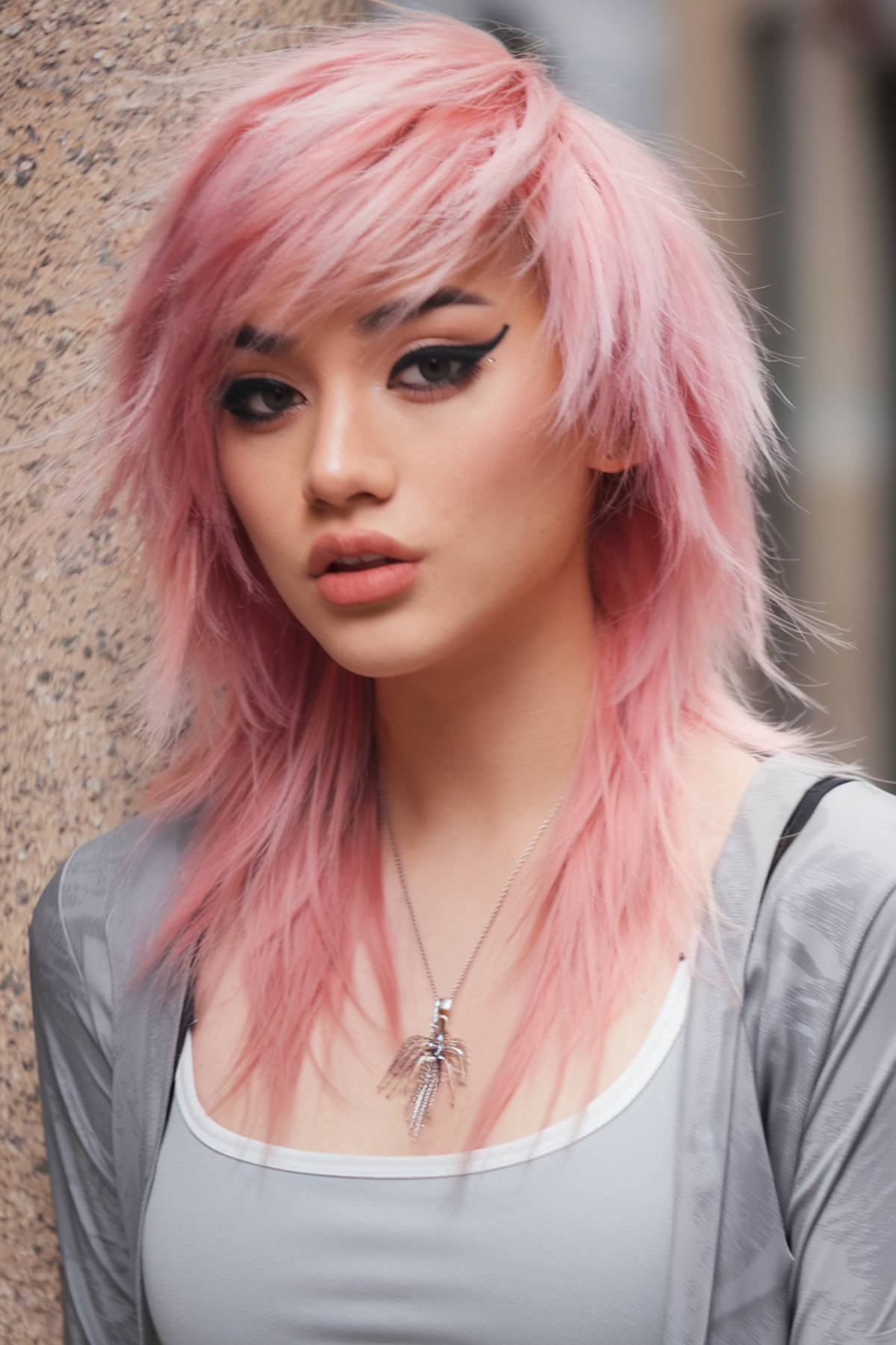 Long pink layered emo haircut with side-swept bangs and textured feathered layers